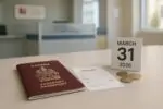 Канадский паспорт на столе рядом с квитанцией, монетами и календарём с датой 31 марта 2026 года
