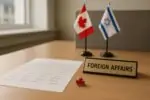 Письмо с подписями на столе в офисе и рядом настольные флаги Канады и Израиля, мягкий дневной свет
