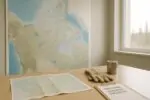 Карта Арктики и планы инфраструктуры на столе в светлом офисе: дороги и приоритетные проекты Канады