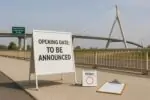 Современный мост на фоне и нейтральная табличка «дата открытия будет объявлена», символ переноса запуска