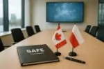 Папка с контрактом SAFE на столе рядом с настольными флажками Канады и Польши, дневной свет