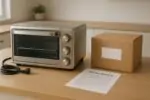 Тостер-духовка из нержавеющей стали на кухонной столешнице, рядом уведомление об отзыве и коробка