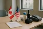 Флаги США и Канады рядом с документами о торговых переговорах и нейтральными товарами на столе