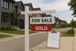 Спокойная улица с домами в Канаде и табличкой «For Sale/Sold», рядом нейтральный график рынка