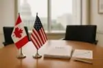 Флаги Канады и США на столе переговоров рядом с документами и графиком, мягкий дневной свет.