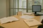 Светлый кабинет колледжа: учебник французского и папка «Accommodation Request» как символ спора в Квебеке.