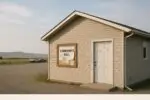 Сельский общественный зал у предгорий под Калгари, тихое утро и доска объявлений с нейтральными афишами