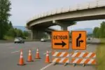 Дневной вид развязки Highway 1 с аккуратными знаками объезда и строительством путепровода вдали