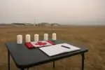 Спокойный мемориальный стол с четырьмя свечами и флагом Канады у базы на прерии, дневной свет