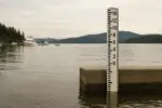 Спокойная набережная Британской Колумбии с приливной рейкой у причала и слегка повышенной отметкой уровня моря