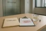 Папка с жалобой и лист проверки на столе в светлом офисе надзора, символ прозрачности стоматологии